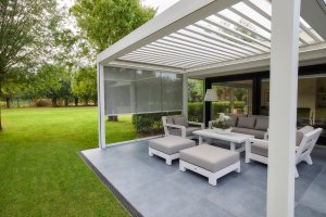 elegante Pergola mit Lamellen zm schwenken, hoch windstabil, wasserdicht, mit seitlichen Schutz in Form von Glas Lamellen oder Stoff wählbar